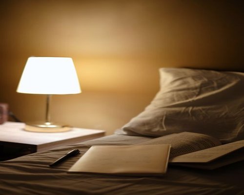 A well-lit bedside table featuring an ambient warm lamp and an open book for relaxed evening reading
