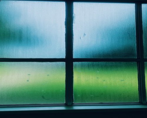 Clean residential window framework letting soft gray light filter through during a rainy day