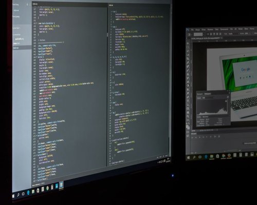 A professional reviewing text layout on a dual-monitor desktop environment with balanced room lighting